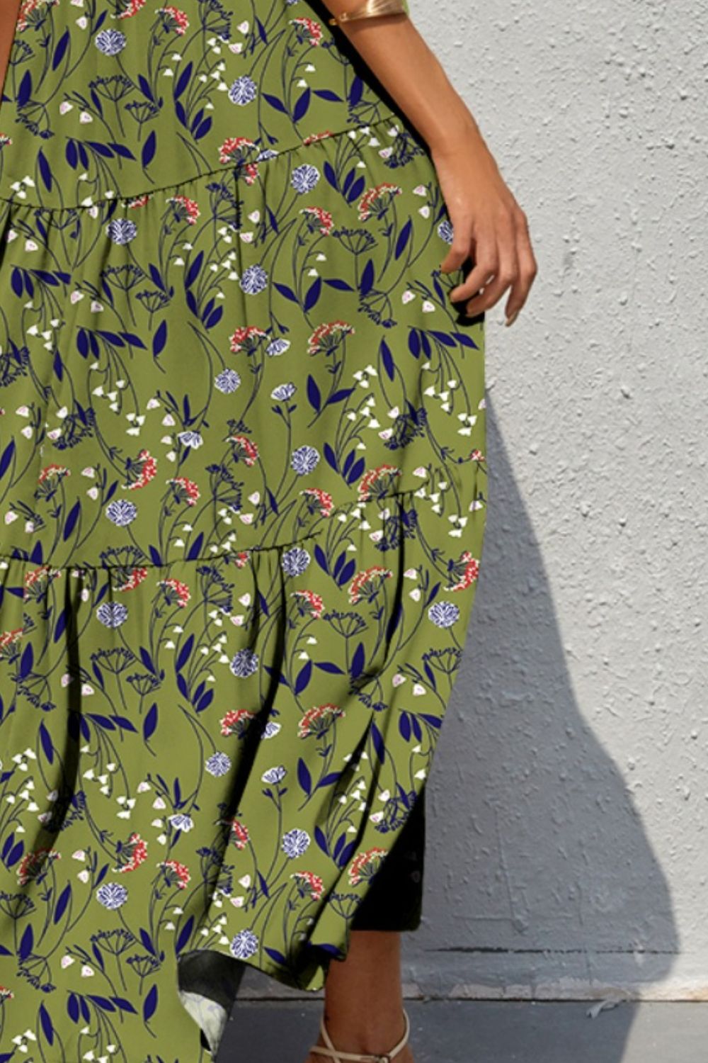 a woman wearing a green floral print dress