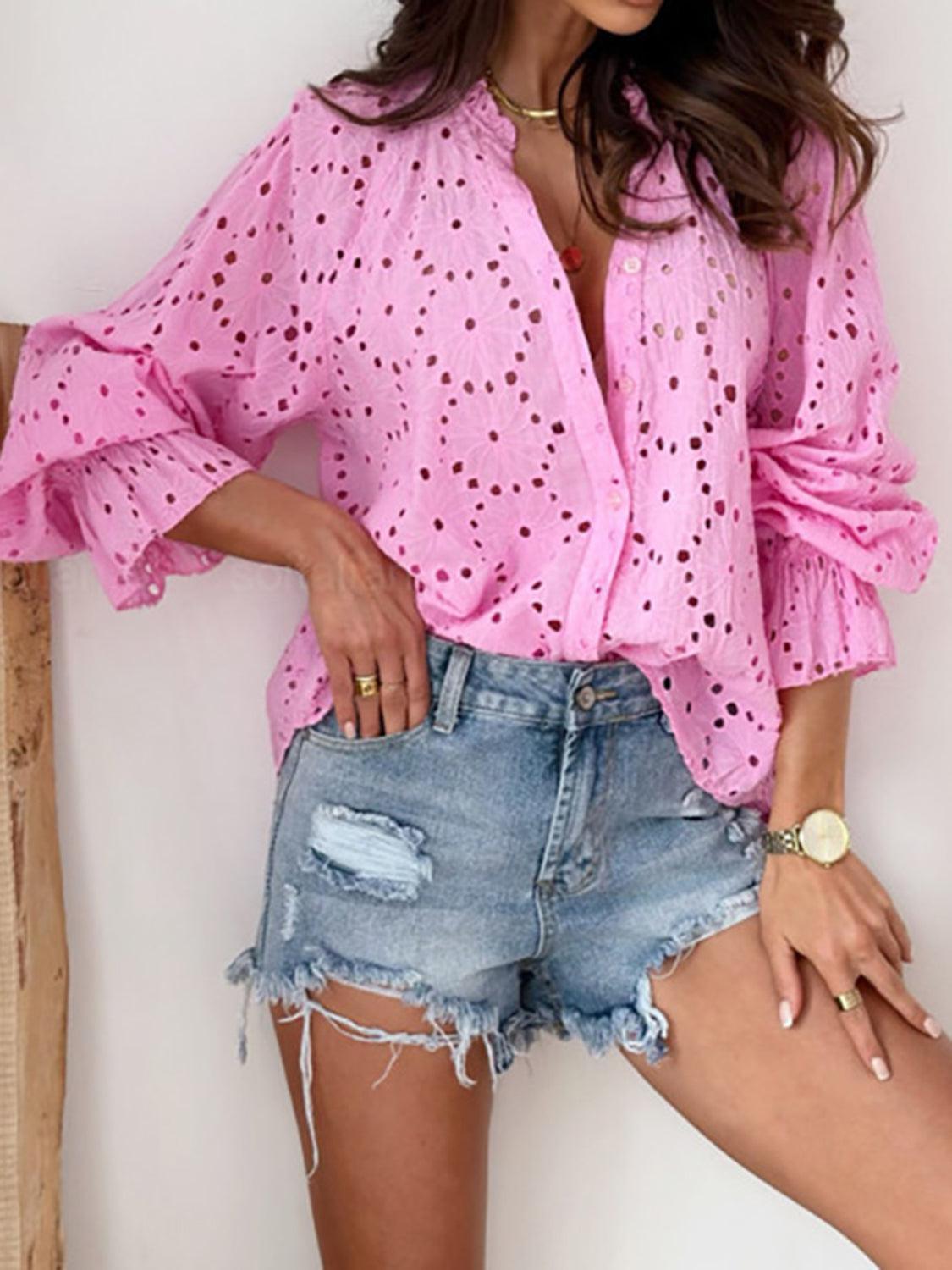 a woman wearing a pink blouse and denim shorts