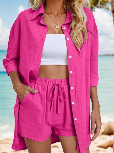 a woman standing on a beach wearing a pink shirt and shorts