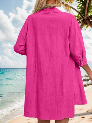 a woman standing on a beach wearing a pink dress