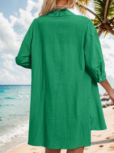 a woman standing on a beach wearing a green dress