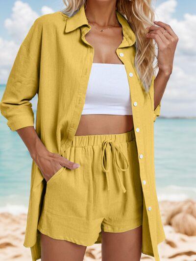 a woman standing on a beach wearing a yellow shirt and shorts