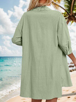 a woman standing on a beach wearing a green dress