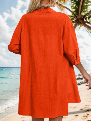 a woman standing on a beach wearing an orange dress