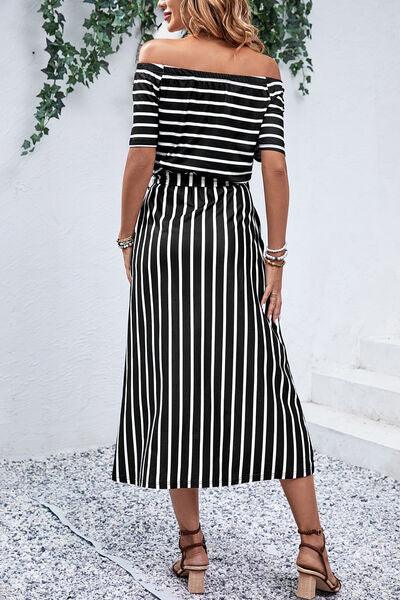 a woman wearing a black and white striped dress