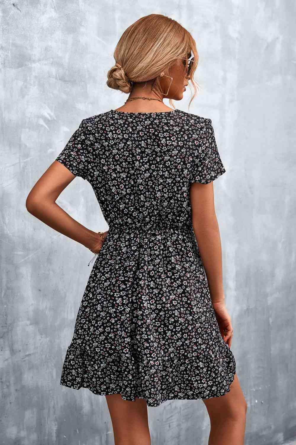 a woman wearing a black floral print dress