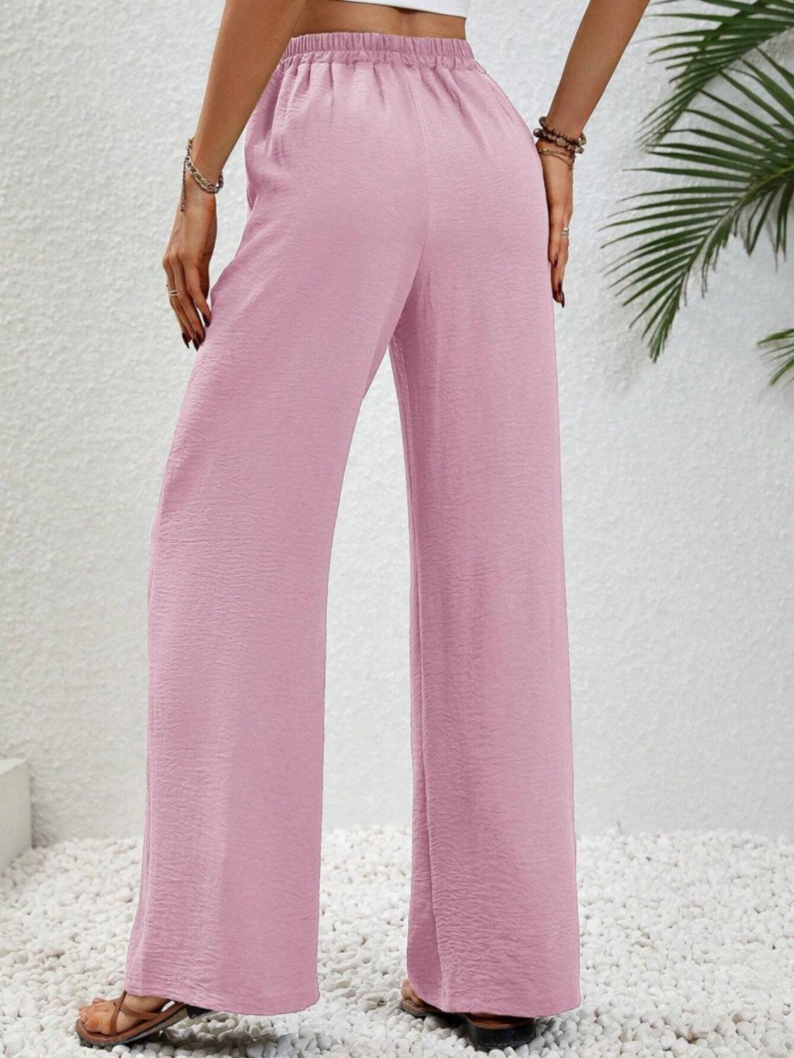 a woman in a crop top and pink pants