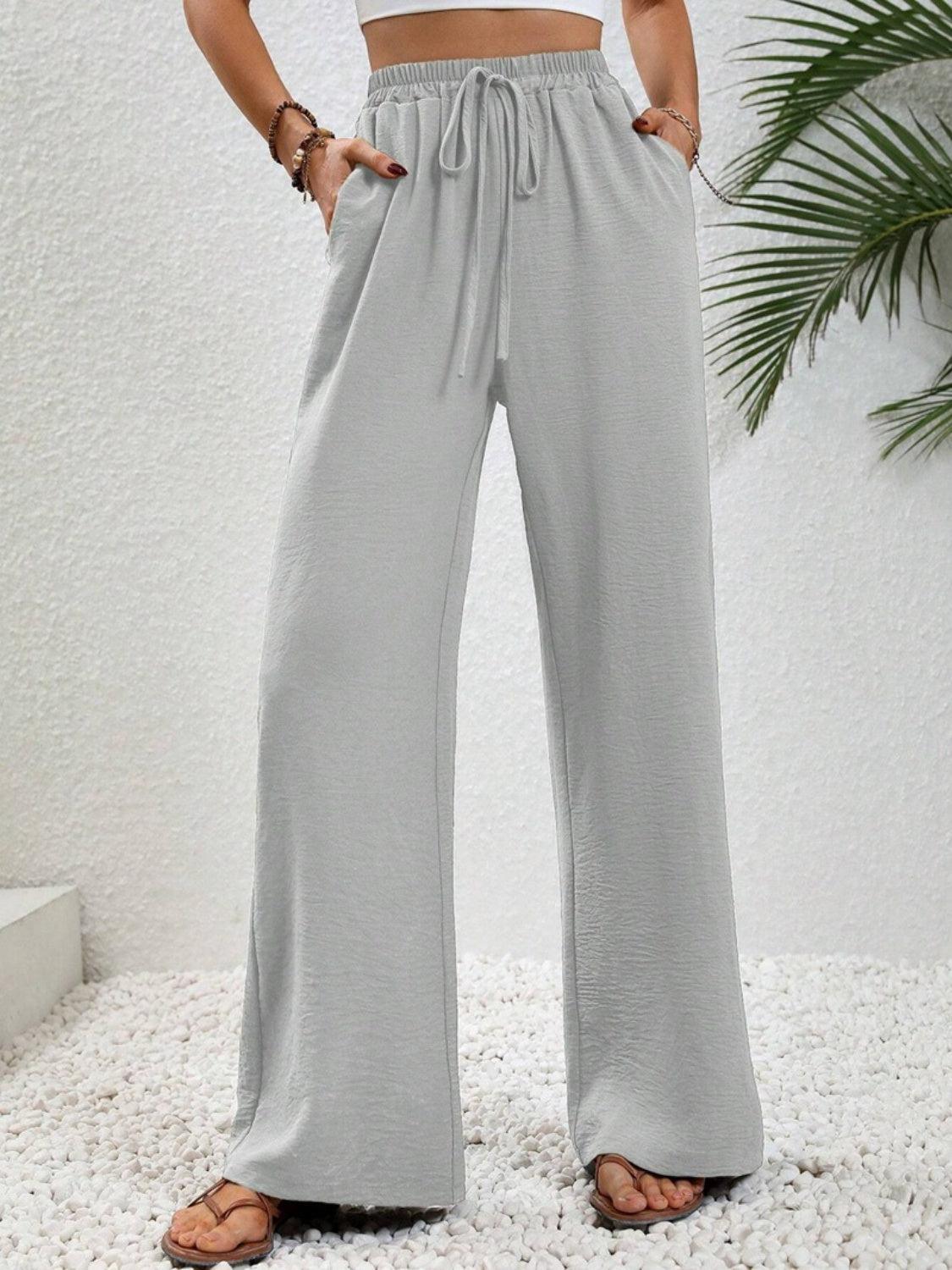 a woman wearing a crop top and wide legged pants