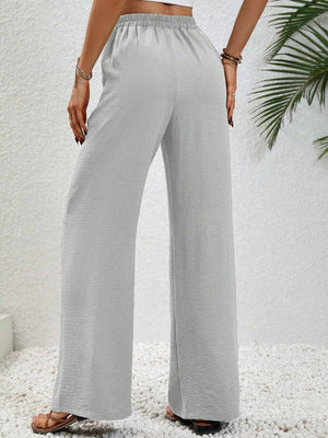 a woman wearing a crop top and wide legged pants