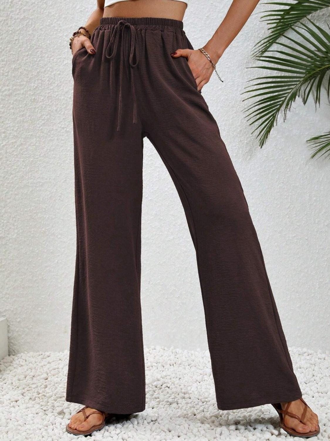 a woman wearing a crop top and wide legged pants