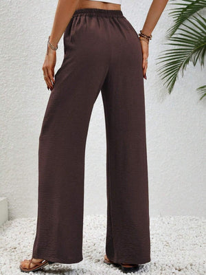 a woman wearing a crop top and wide legged pants