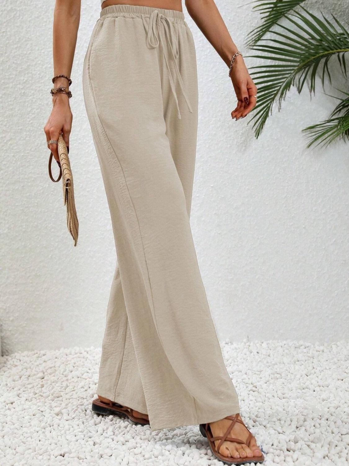 a woman in a crop top and wide legged pants