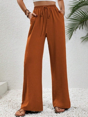 a woman wearing a crop top and wide legged pants