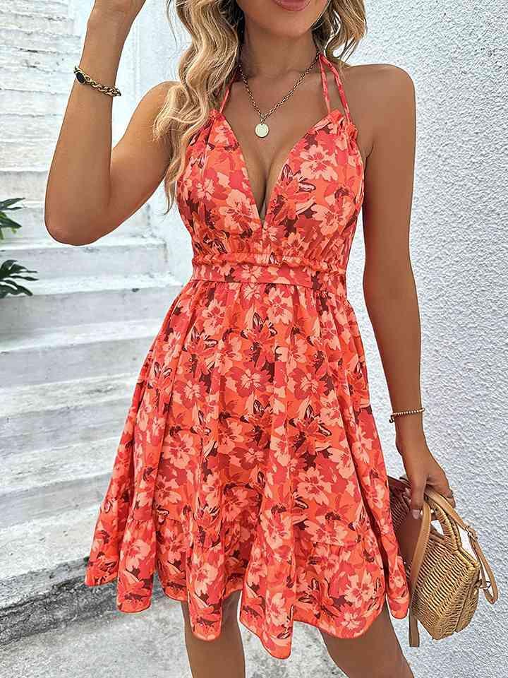 a woman in an orange floral print dress