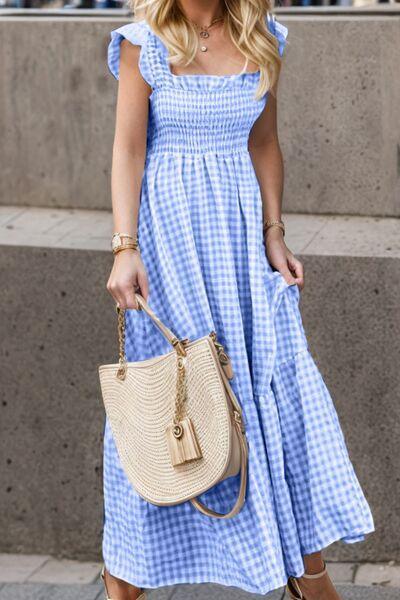 a woman in a blue dress carrying a straw bag