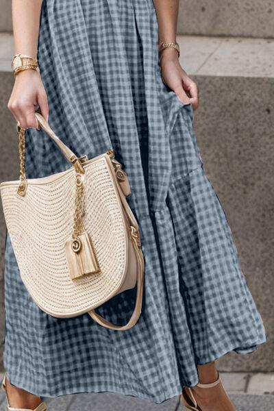 a woman in a blue dress carrying a beige purse