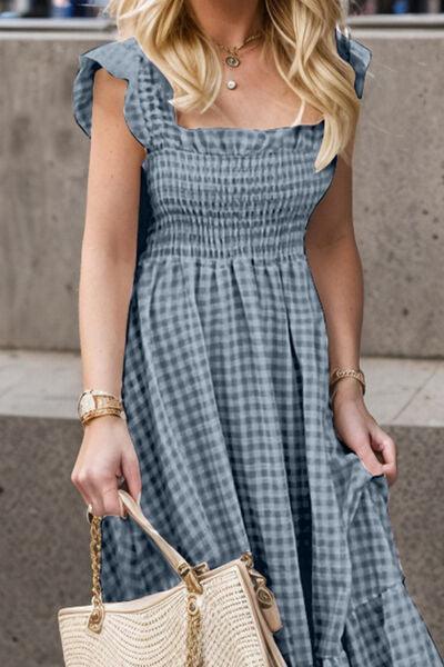 a woman in a blue dress carrying a white purse