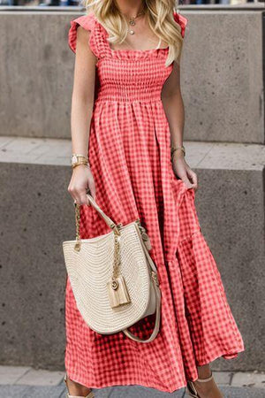 a woman in a red and white dress carrying a beige purse