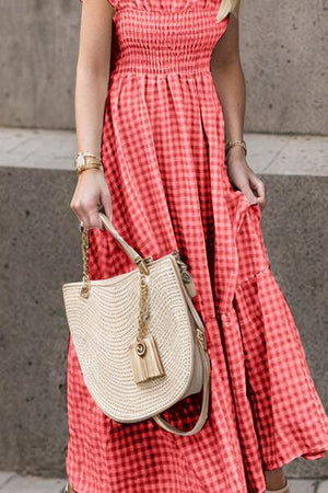 a woman in a red dress carrying a white purse