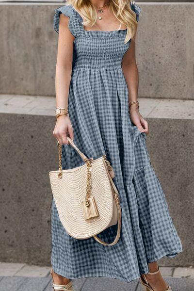 a woman in a blue dress carrying a white purse