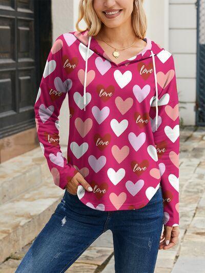a woman wearing a pink hoodie with hearts on it