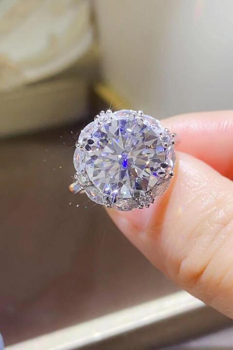 a person holding a diamond ring in their hand