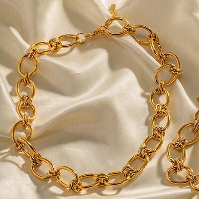 a close up of a gold necklace on a white cloth