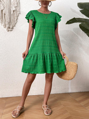 a woman in a green dress and straw hat