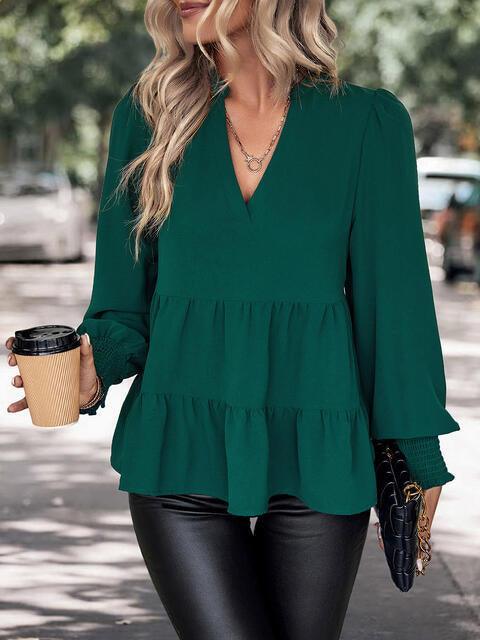 a woman in a green top holding a cup of coffee