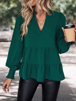 a woman in a green top holding a cup of coffee