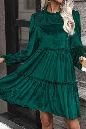 a woman wearing a green dress with long sleeves