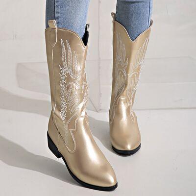 a woman wearing a pair of gold cowboy boots