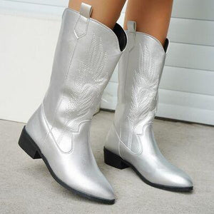 a close up of a person wearing silver cowboy boots