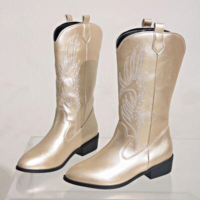 a pair of gold cowboy boots sitting on top of a clear shelf