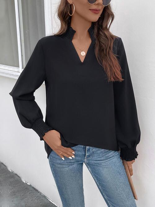 a woman wearing a black blouse and jeans