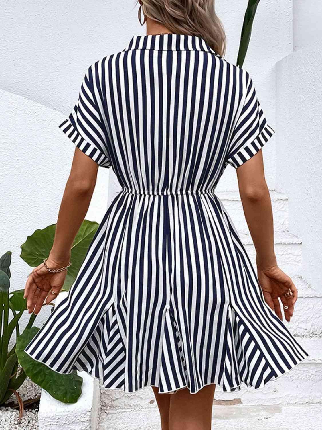 a woman in a striped dress walking down the street