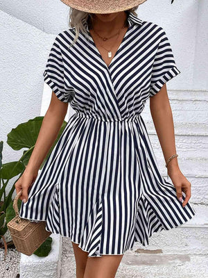 a woman wearing a striped dress and straw hat