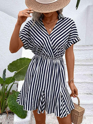 a woman wearing a striped dress and straw hat