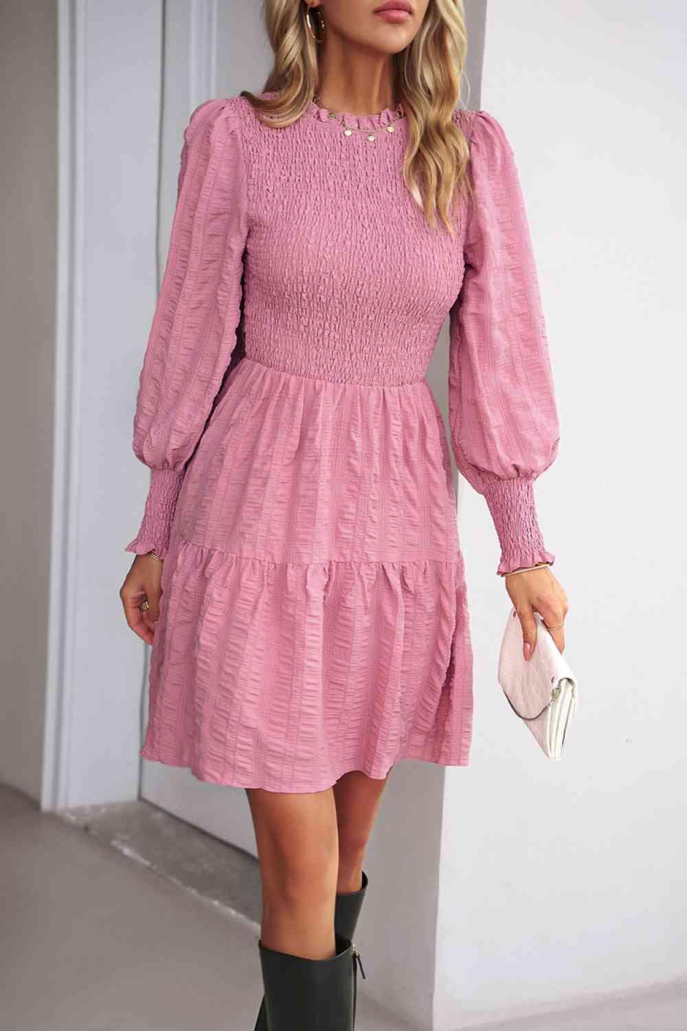 a woman wearing a pink dress and cowboy boots
