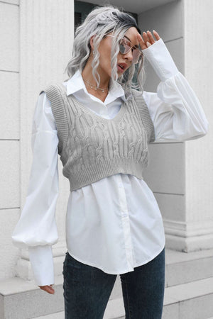 a woman with grey hair wearing a white shirt and jeans