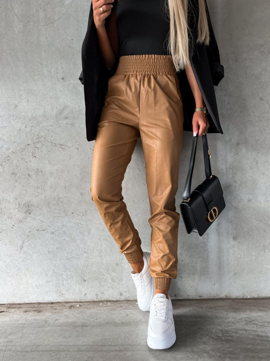 a woman wearing a black top and tan pants