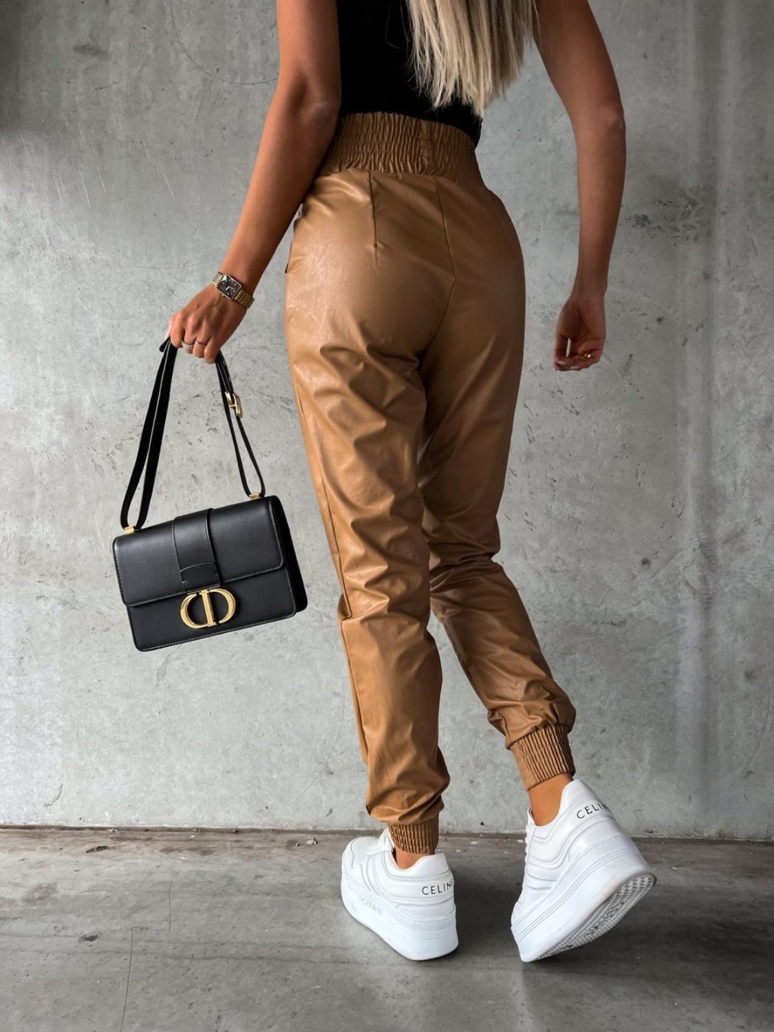 a woman carrying a black handbag and a black purse