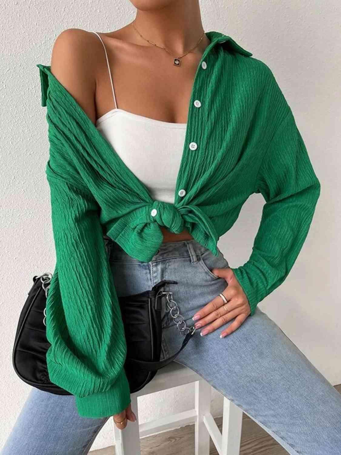 a woman sitting on a chair wearing a green sweater