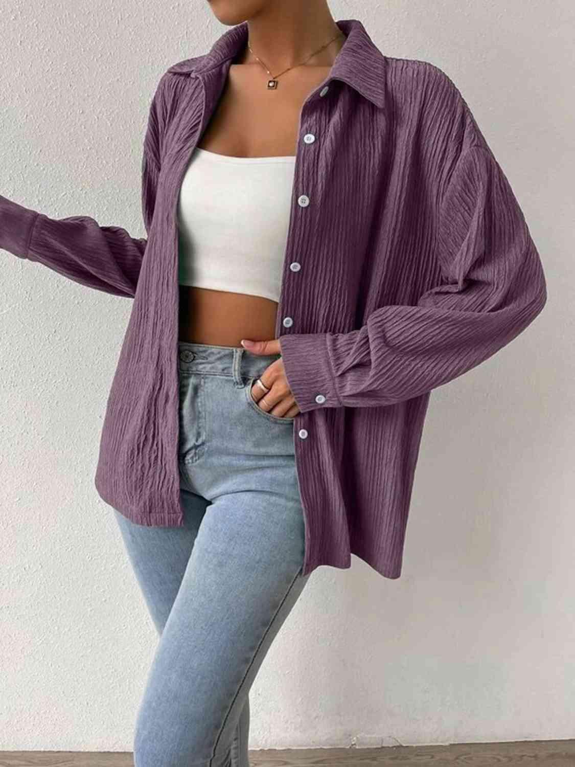 a woman wearing a purple jacket and jeans