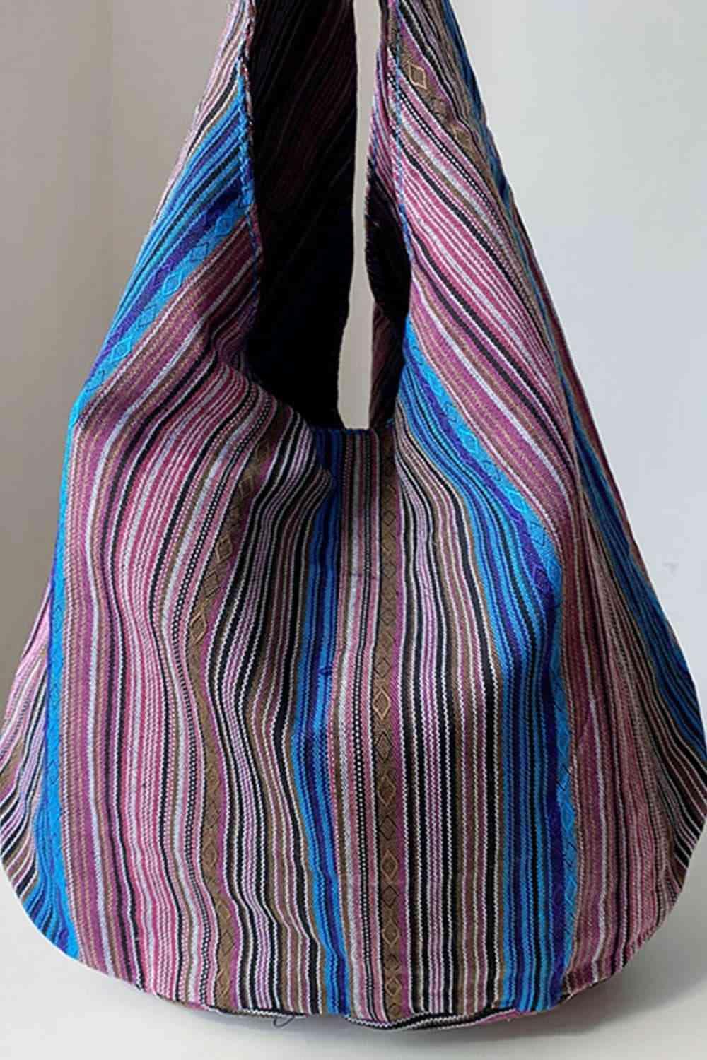 a multicolored striped bag sitting on top of a white table