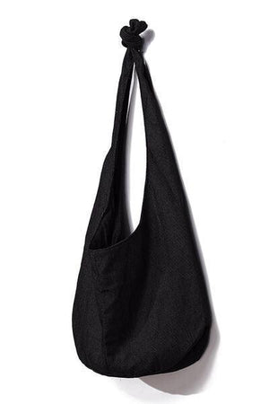 a black bag hanging on a white wall