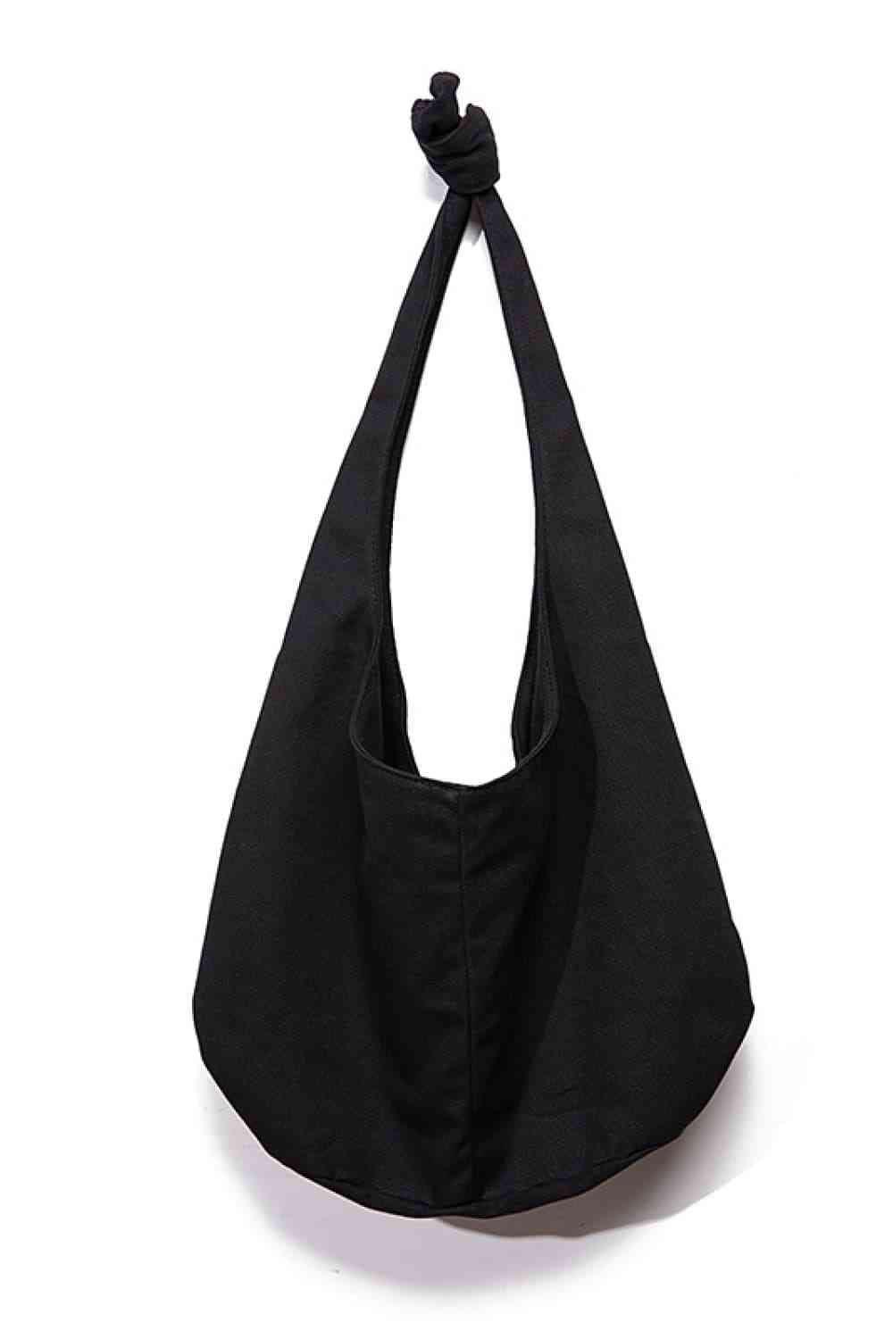 a black bag hanging on a white wall