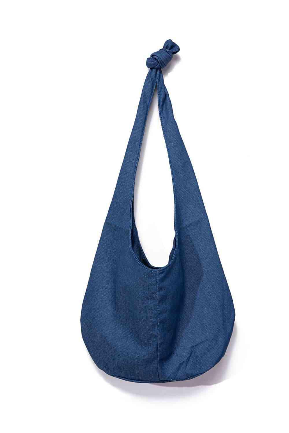 a blue bag hanging on a white wall