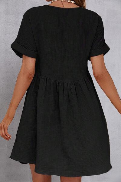 a woman wearing a black dress with short sleeves