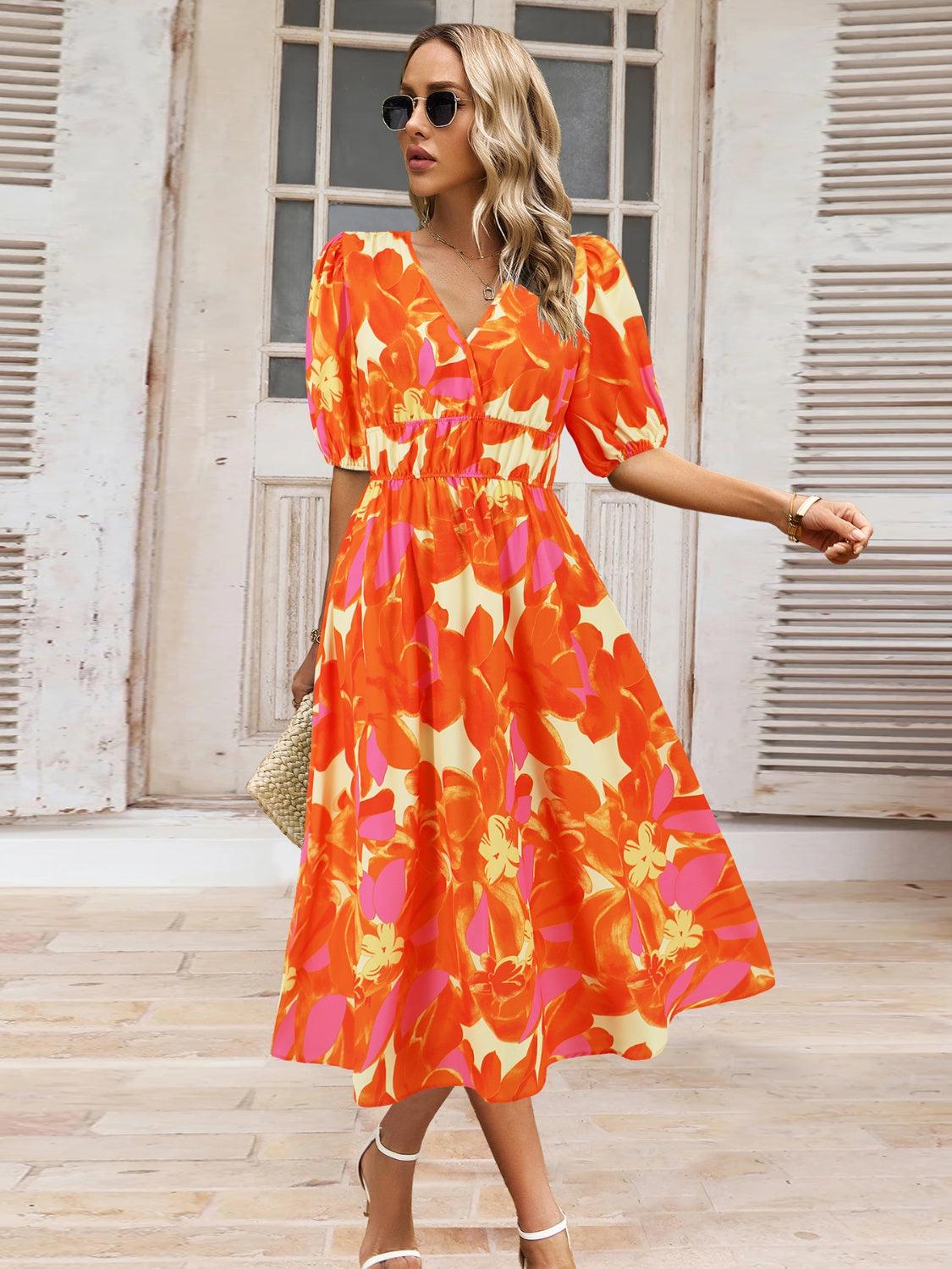 a woman in an orange and pink floral print dress